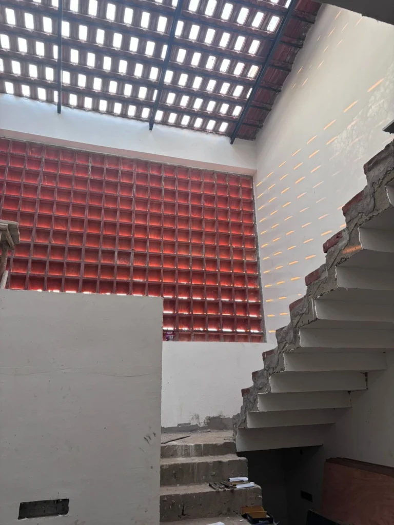Stair hall — cantilevered flight against the glowing jali